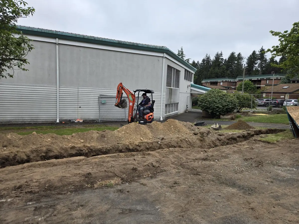 Excavation underway for EV charger conduit runs at a DSHS fleet lot