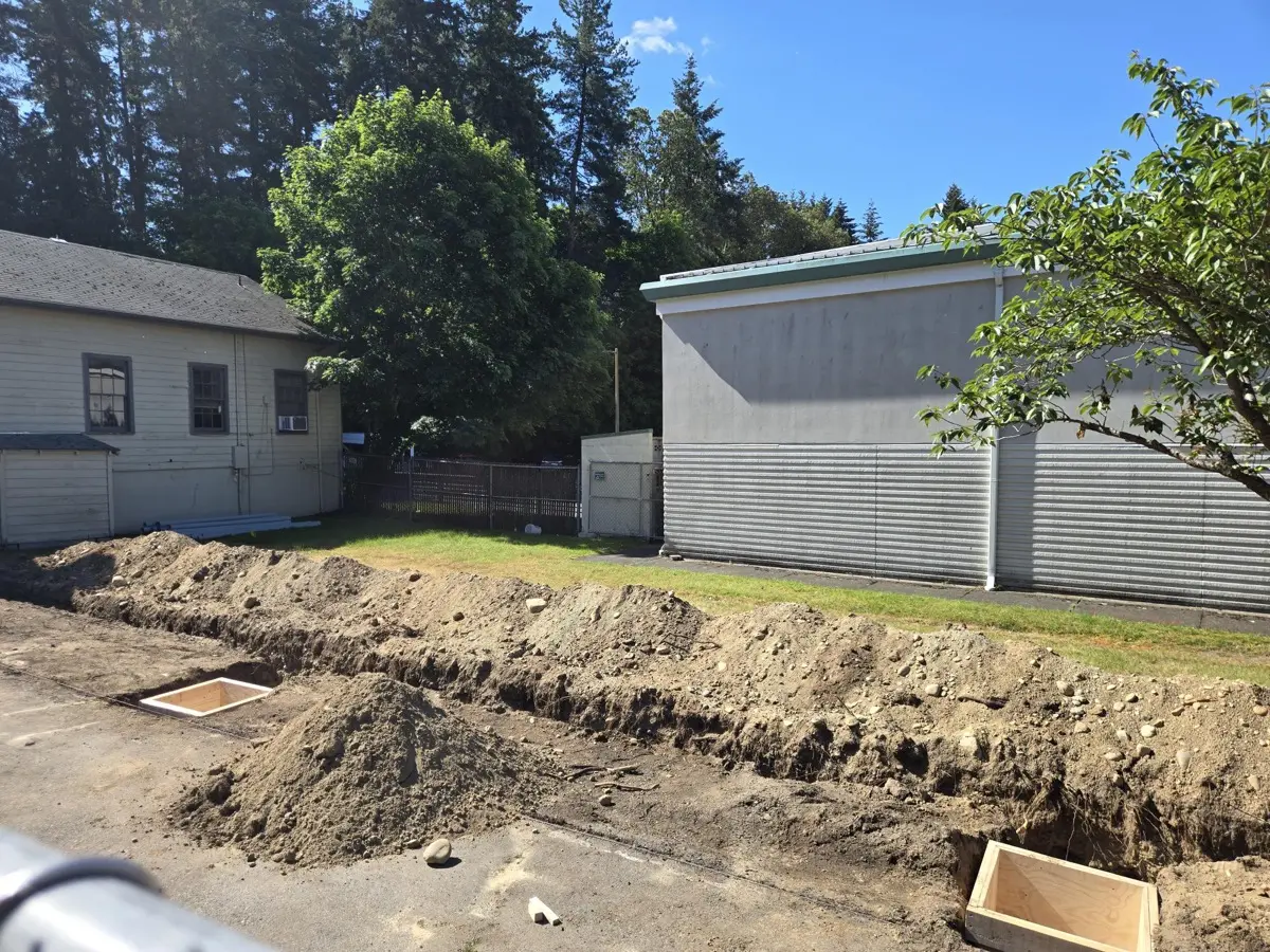 Wooden footing forms set in the trench for charging station bases