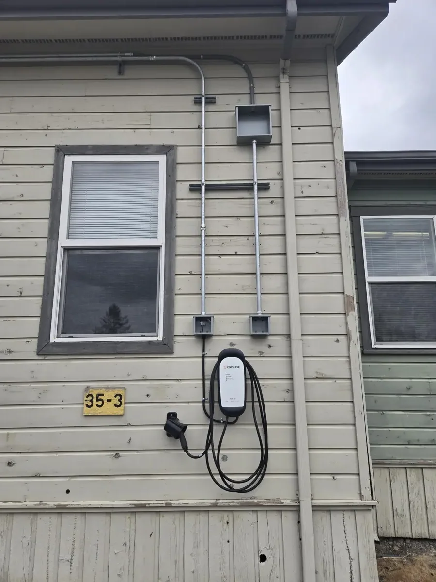 Completed wall-mounted EV charging units with conduit runs on building exterior