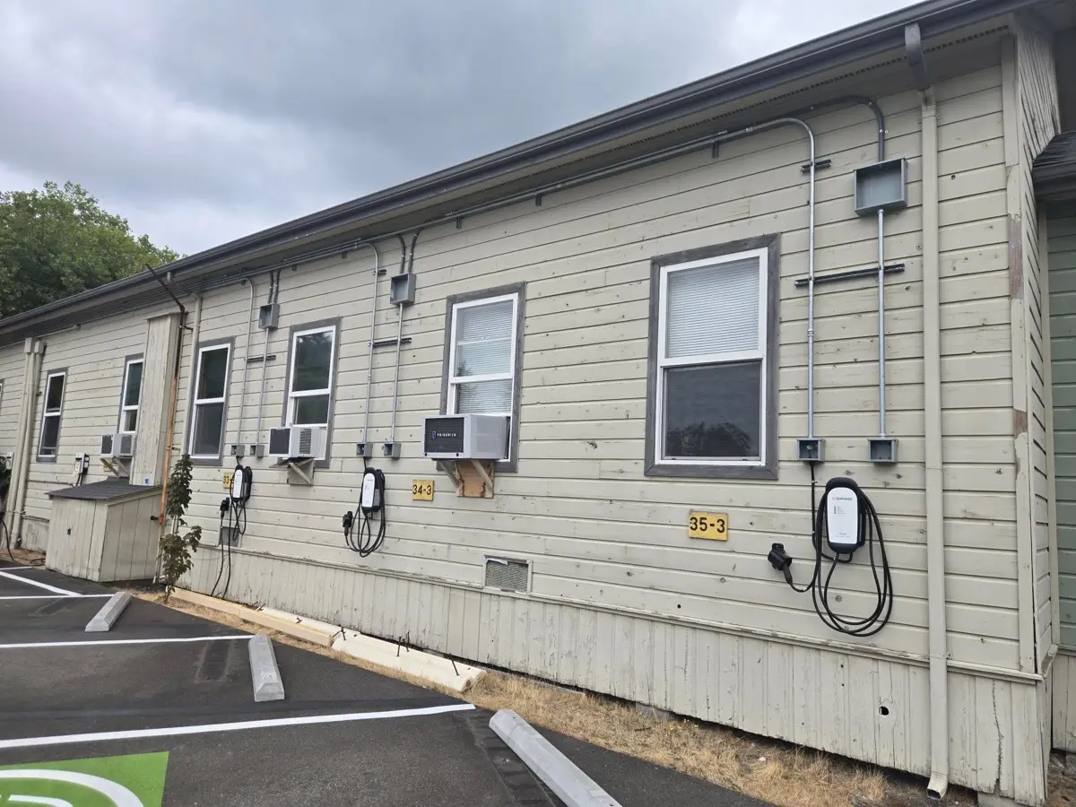 Wall-mounted EV charging units with conduit runs on building exterior